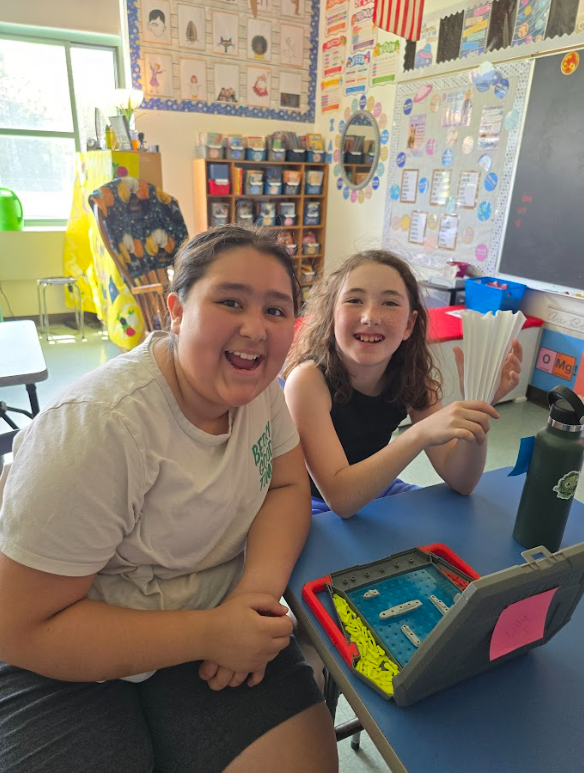 Image of students sitting at a table playing a game of Battleship