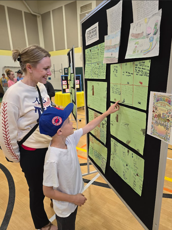 Image of a family looking at a STEAM project displayed on a board
