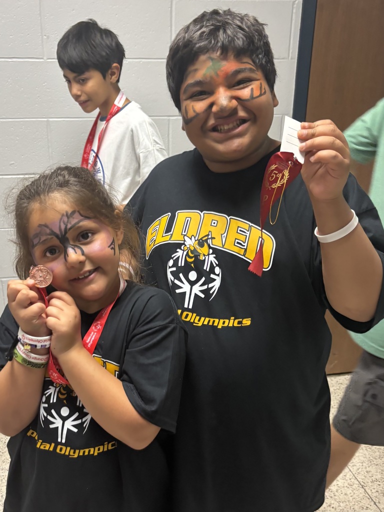 Student athletes smiling and holding awards at the Special Olympics