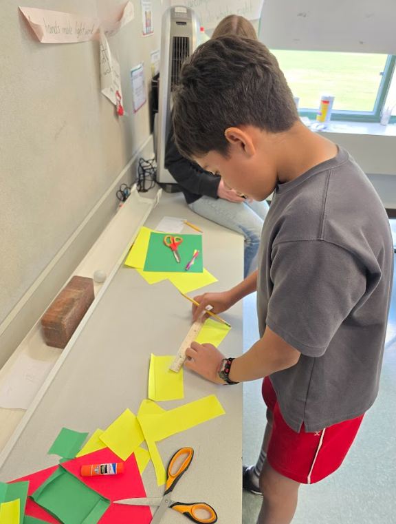 Image of a student measuring paper for an egg car racer