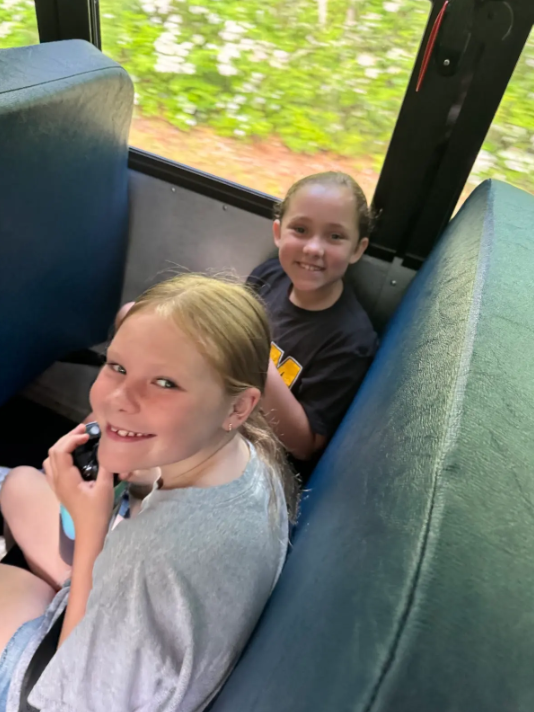 Students sit in a seat on a school bus on their way to a field trip
