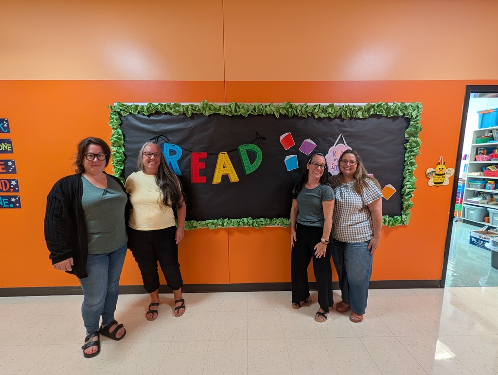 Image of teachers standing in front of a 2-toned orange wall