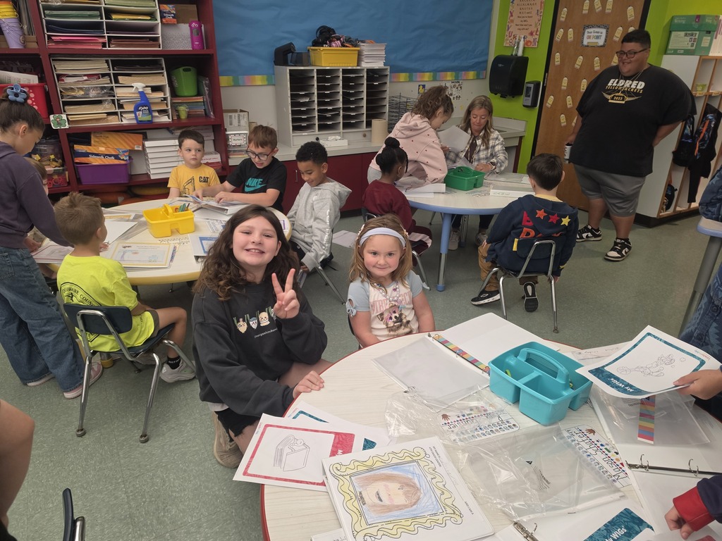 Image of students helping their peers put together binder for their Leader in Me leadership skills