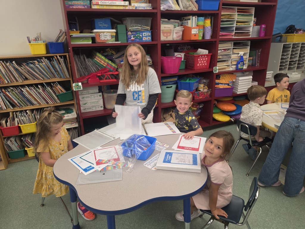 Image of students helping their peers put together binder for their Leader in Me leadership skills