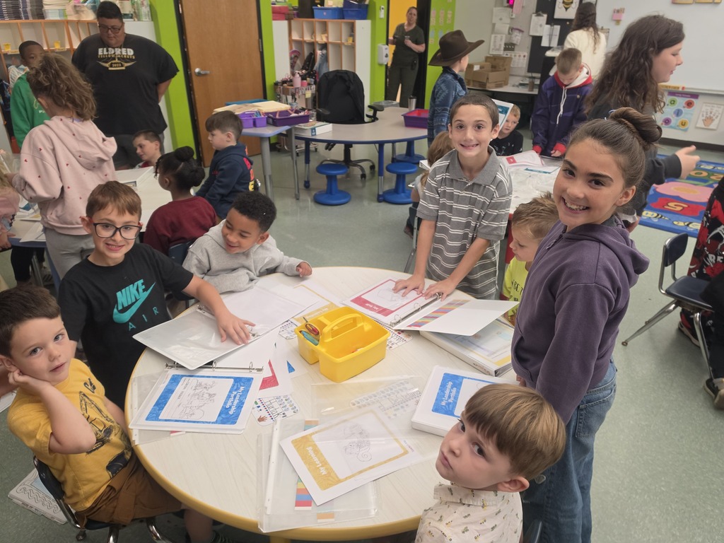 Image of students helping their peers put together binder for their Leader in Me leadership skills