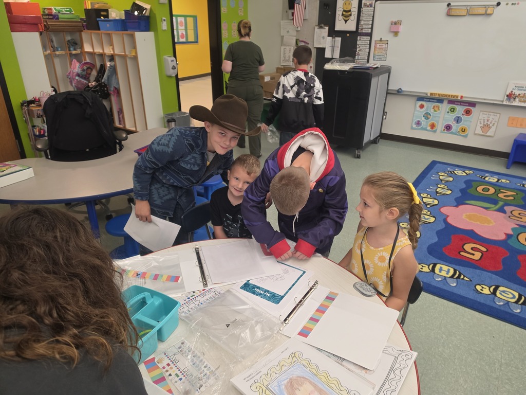 Image of students helping their peers put together binder for their Leader in Me leadership skills