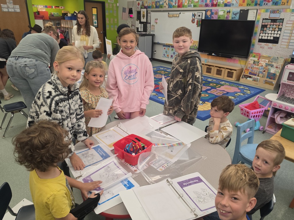Image of students helping their peers put together binder for their Leader in Me leadership skills