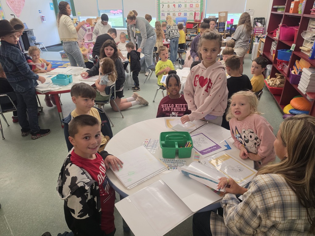 Image of students helping their peers put together binder for their Leader in Me leadership skills
