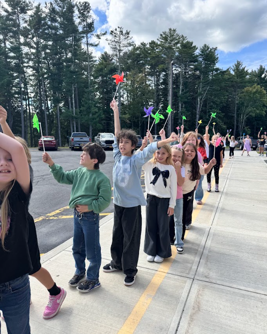 Image of student parading with colorful pinwheels in their hands