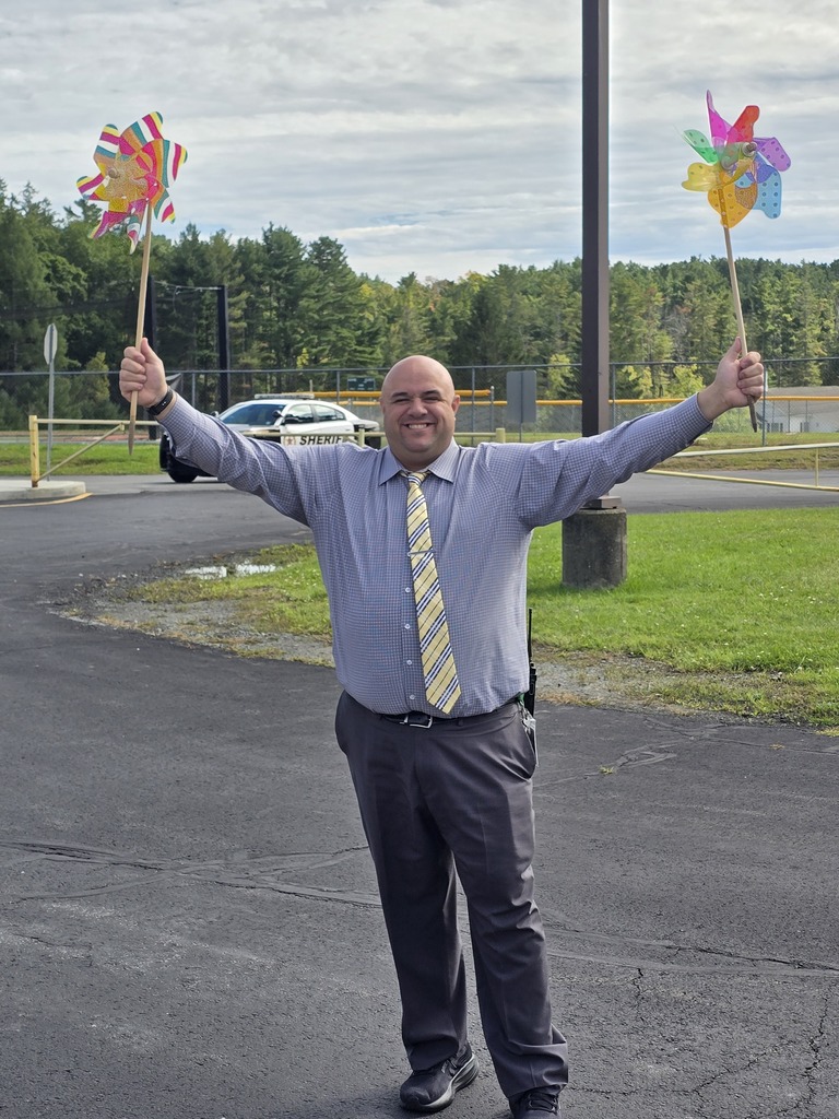 Image of a man holding two large colorful pinwheels in each hand