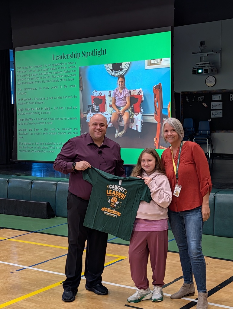 Image of student posing with her school principal and counselor holding a green shirt with a cartoon bee on it that says "caught being a leader"