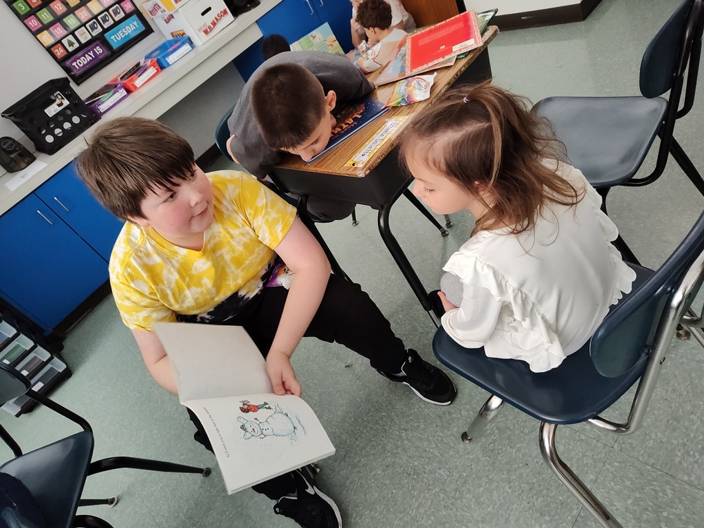 Image of 6th grade students reading to PreK students
