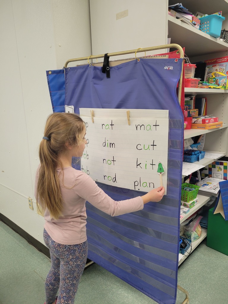 a student works at a board on a word game