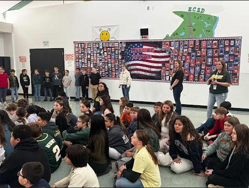 Image of students sitting in front of the Mackenzie Elementary Wall of Honor