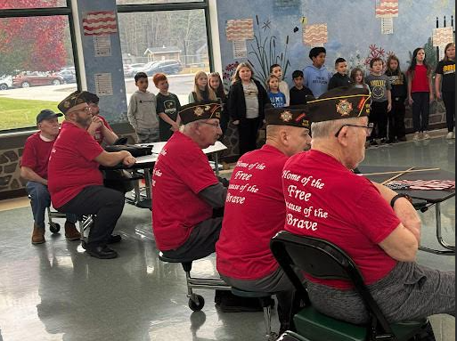 Image of veterans who were invited to a Veterans Day event, sitting listening to a presentation