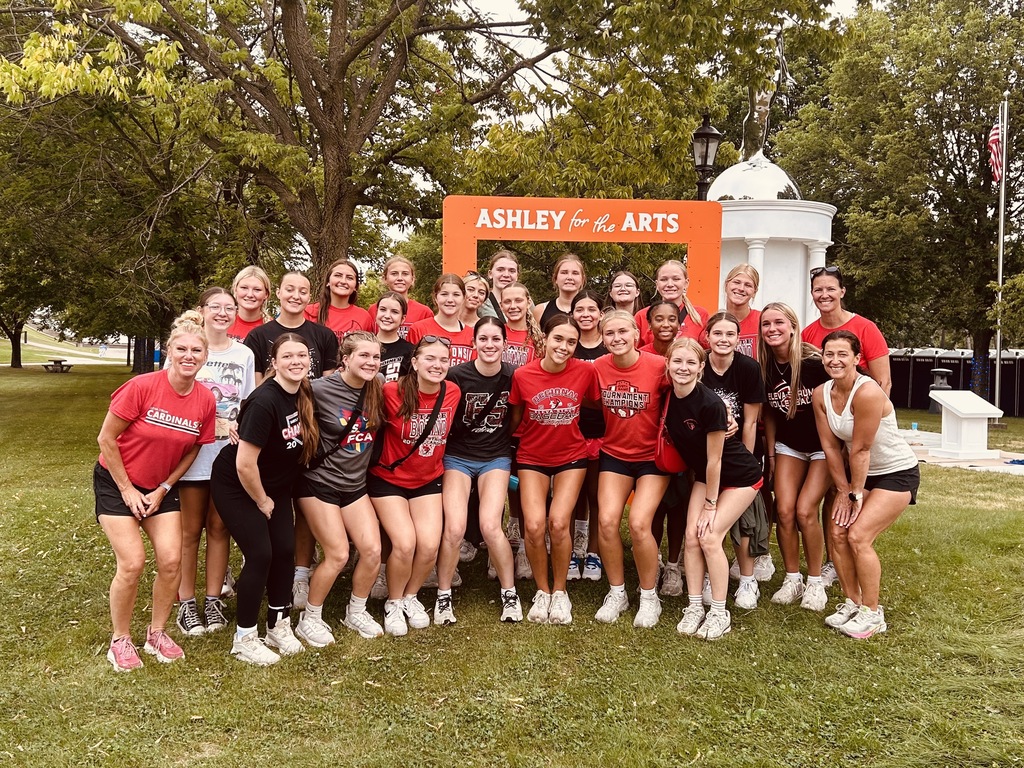 Group of Lady Cardinals stands in front of Ashley for the Arts sign