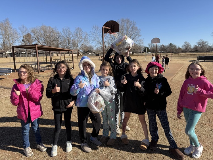 Mrs. Burton’s students pick up trash to tidy up their playground. 