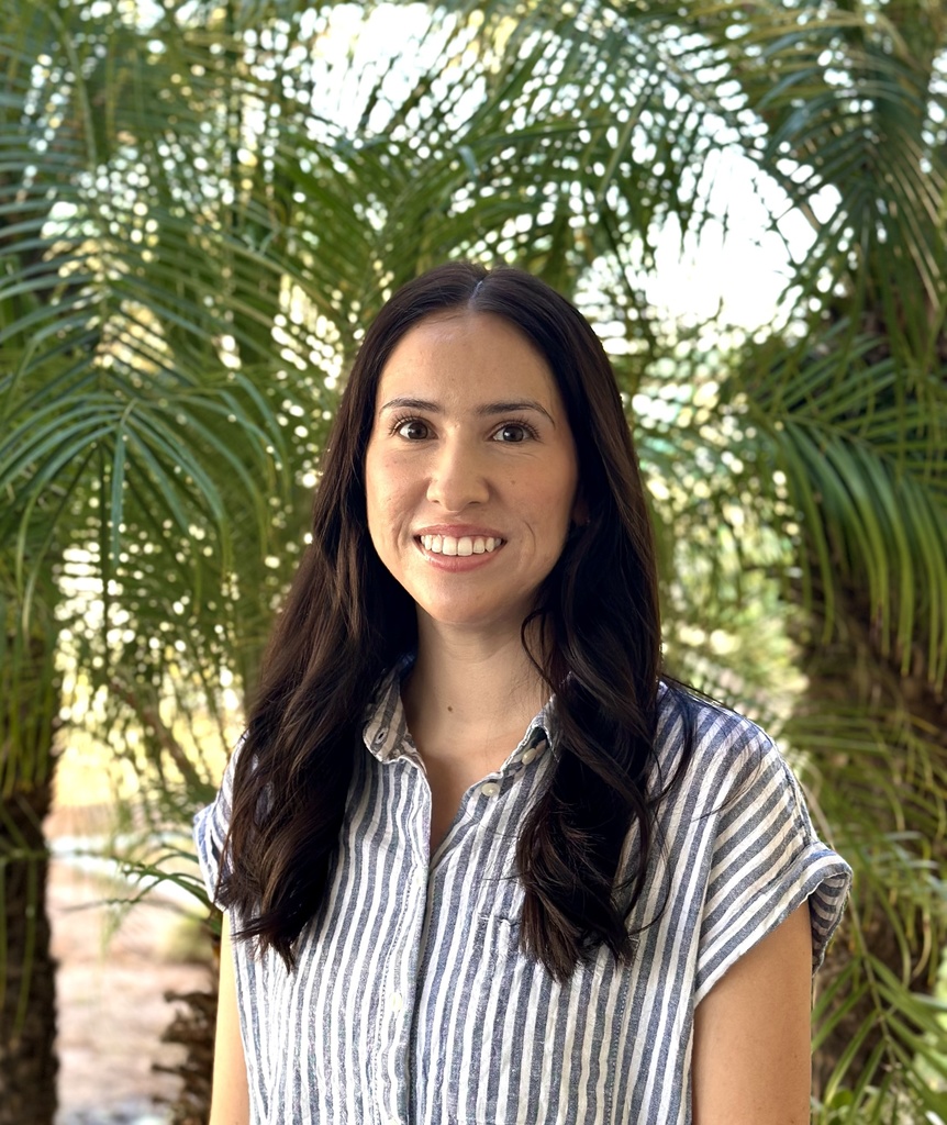 MIss Taryn standing in front of the palm tree
