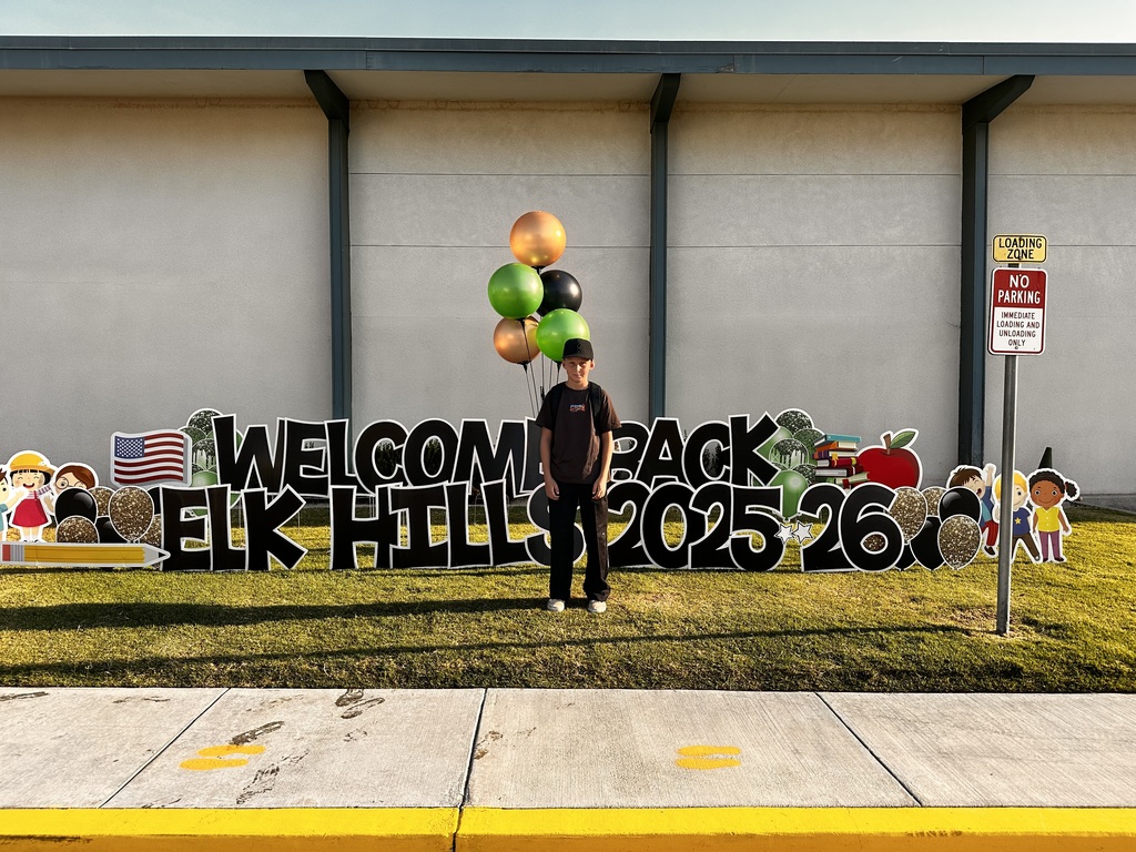 Student in front of yard card