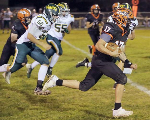 Wells High School football player running the ball vs Eureka Vandals