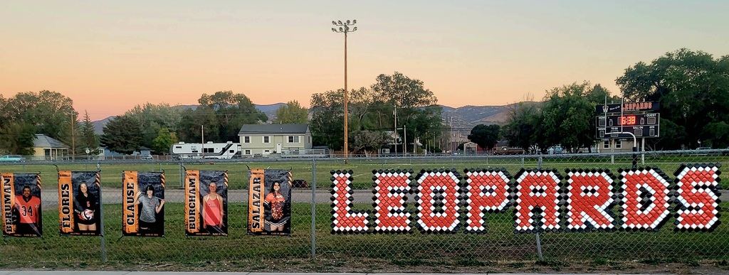 Wells High School Leopards senior fall athlete banners hanging on the football field fence