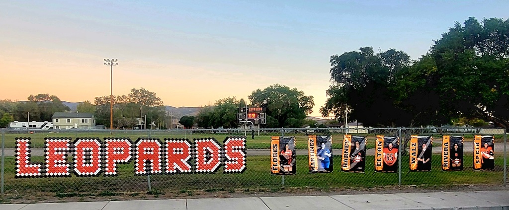 Wells High School Leopards senior fall athlete banners hanging on the football field fence