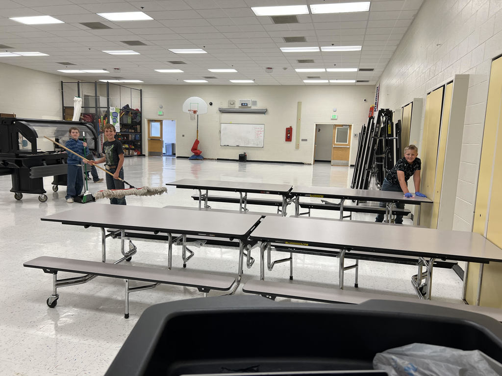 elementary school students helping clean up after lunch