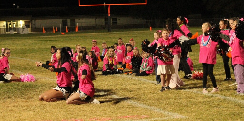 Wells High cheerleaders working with the mini cheerleaders during half time of the Wells Leopards vs Pyramid Lake Lakers football game