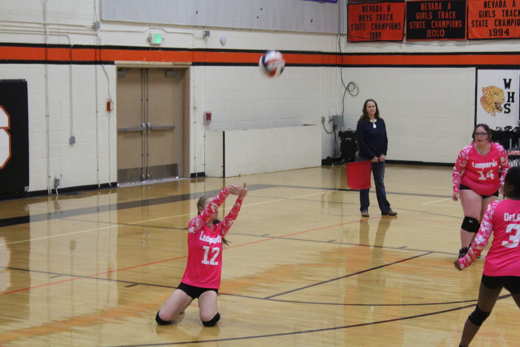 Wells High School JV girls volleyball team members playing against the Lund High School JV volleyball girls