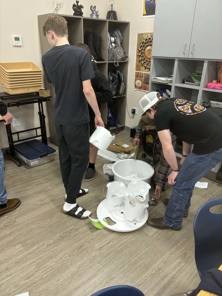 Leelyn and Danner, 8th grade, and Moshe, 12th grade, work together to assemble a hydroponic tpwer. 