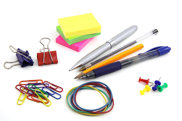 Various office supplies, paperclips, pins, post its, pens, rubberbands