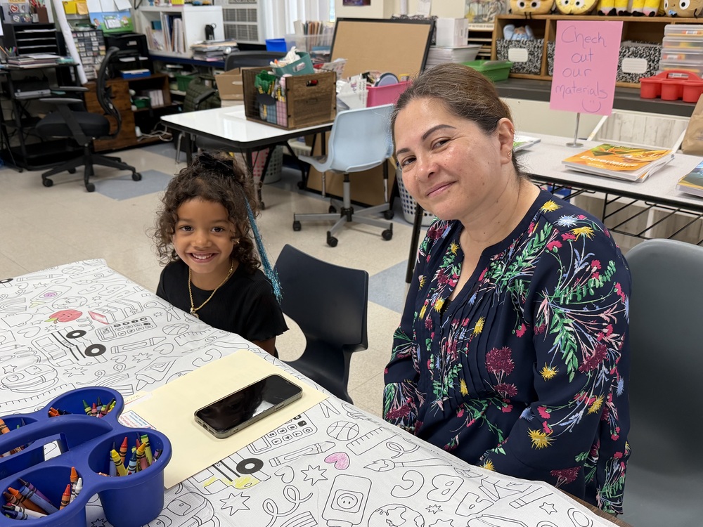 A parent and child sit at a table together