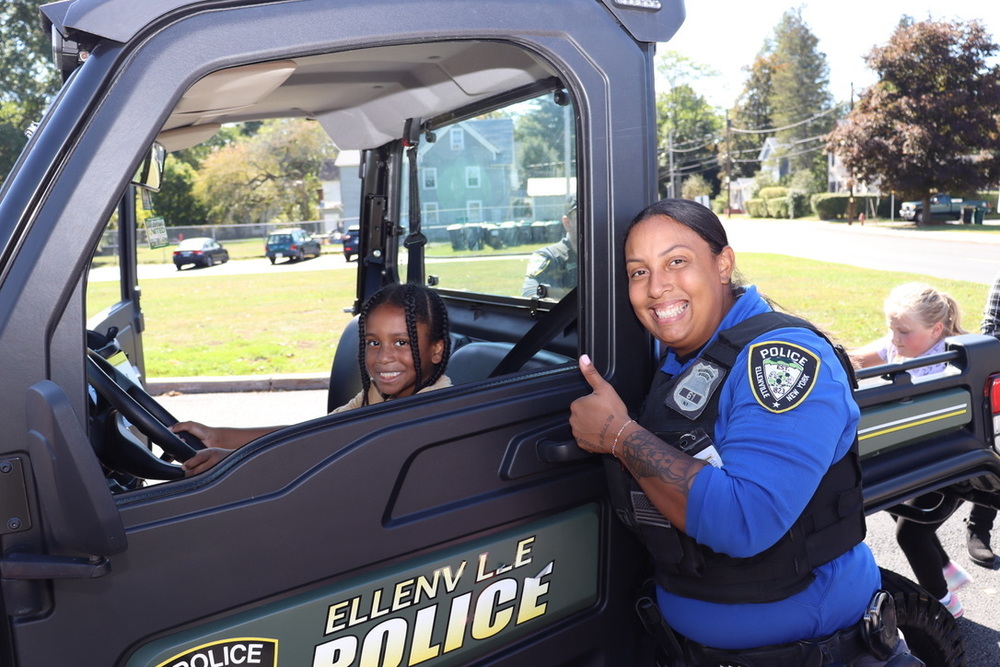 Student tries out the front seat of a police car at annual "Driving Ellenville" event