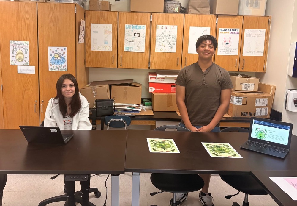 Two students behind a table