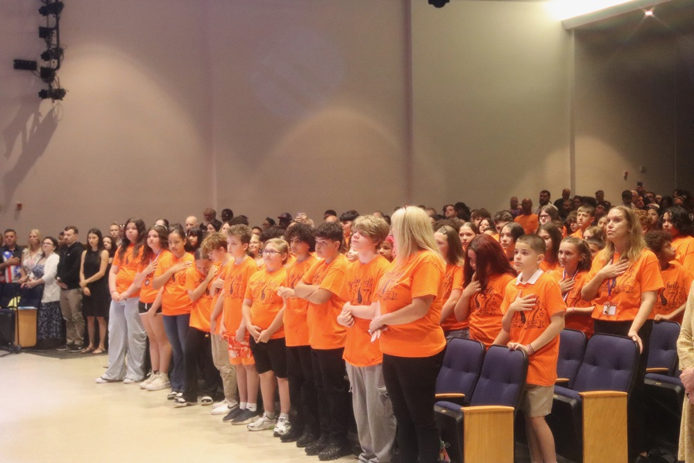 A group of Grade 6 students wearing matching orange shirts