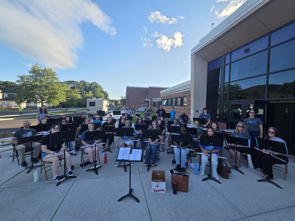 Photo of a band sitting outside of a school