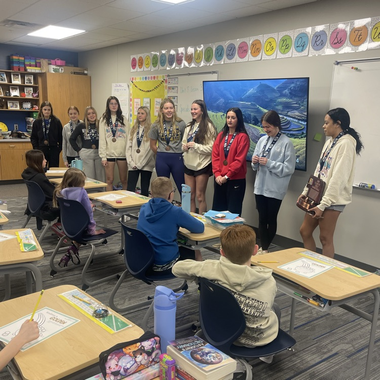girls basketball team talking to third grade 