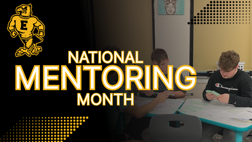Three students sit at a table working with papers beneath bold yellow text reading “National Mentoring Month,” with the Emmetsburg logo on a black and gold background.