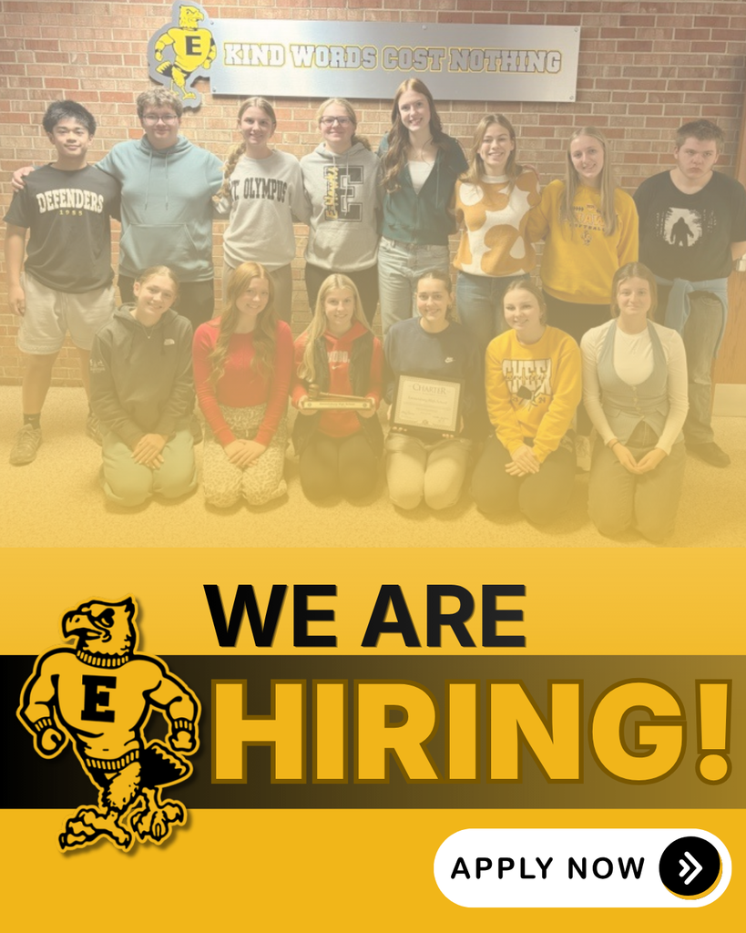 Group of student leaders pose with a charter award beneath a “Kind Words Cost Nothing” sign, alongside a “We Are Hiring!” message and apply now button.