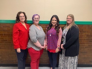 Mrs. Reames, Mrs. Krieger, Mrs. Lobaugh, Mrs. Brown standing in front of the wall.