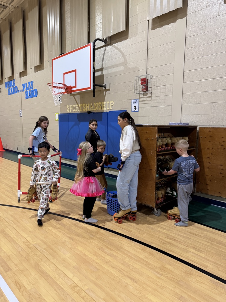 4th & 5th grade Leadership students helping put on skates in PE.