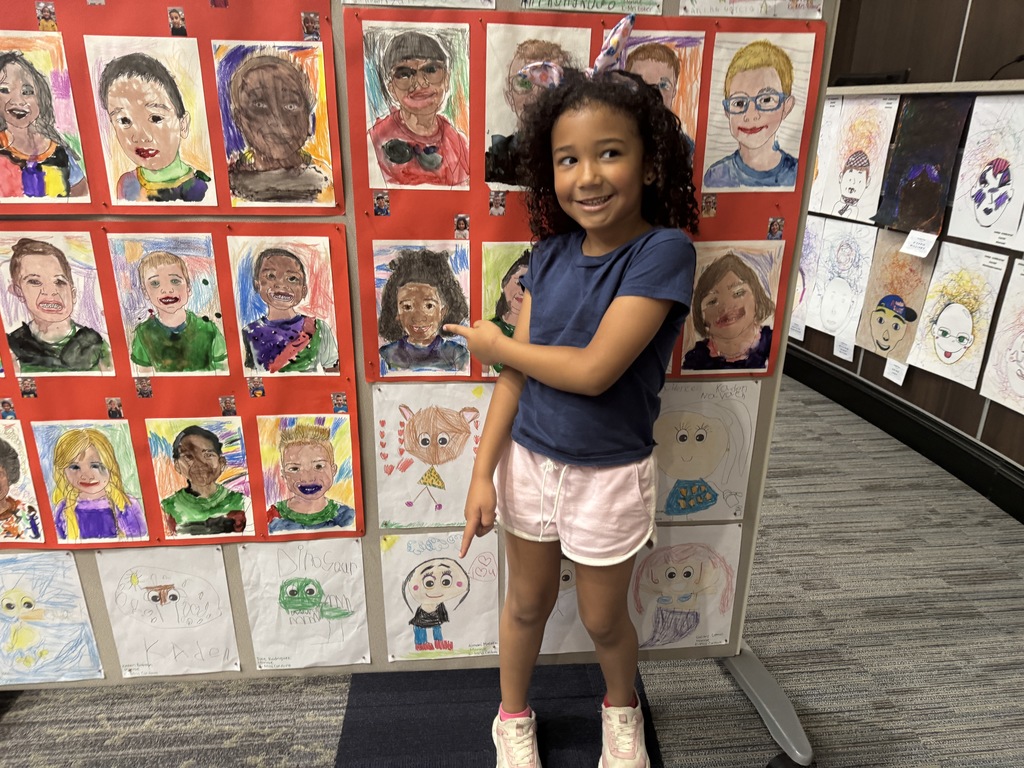 Elementary student standing with her art