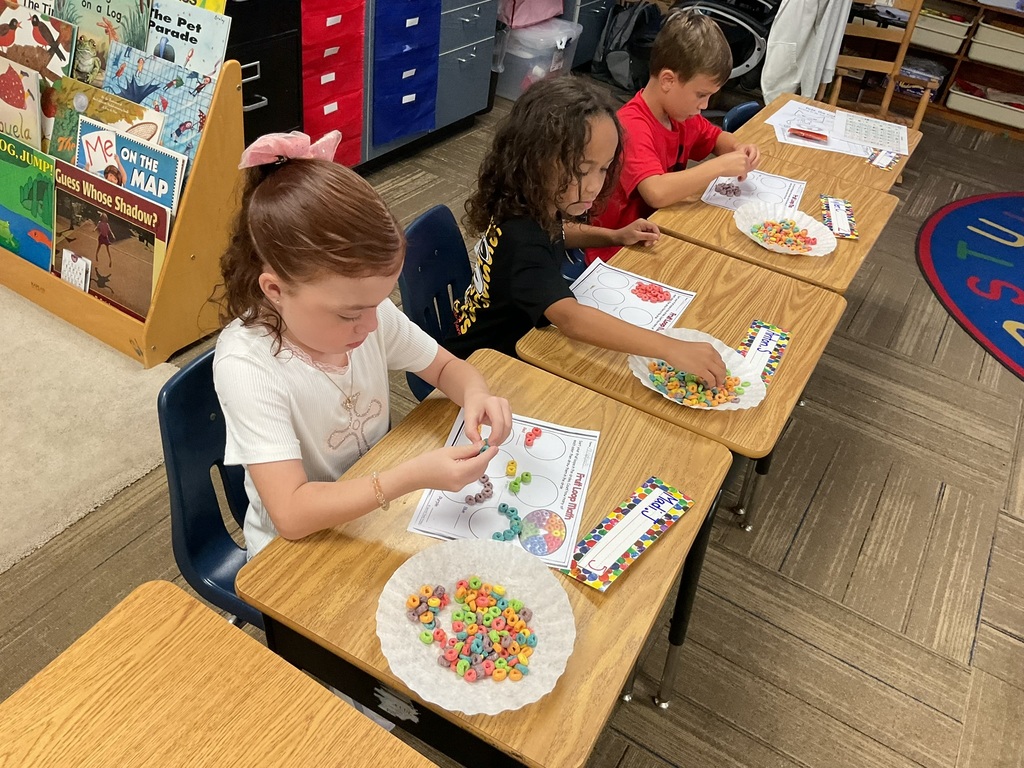 1st grade students sorting & graphing fruit loops by color