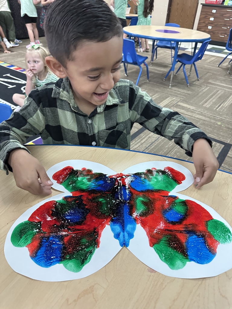 Young man in green plaid & painting a butterfly!