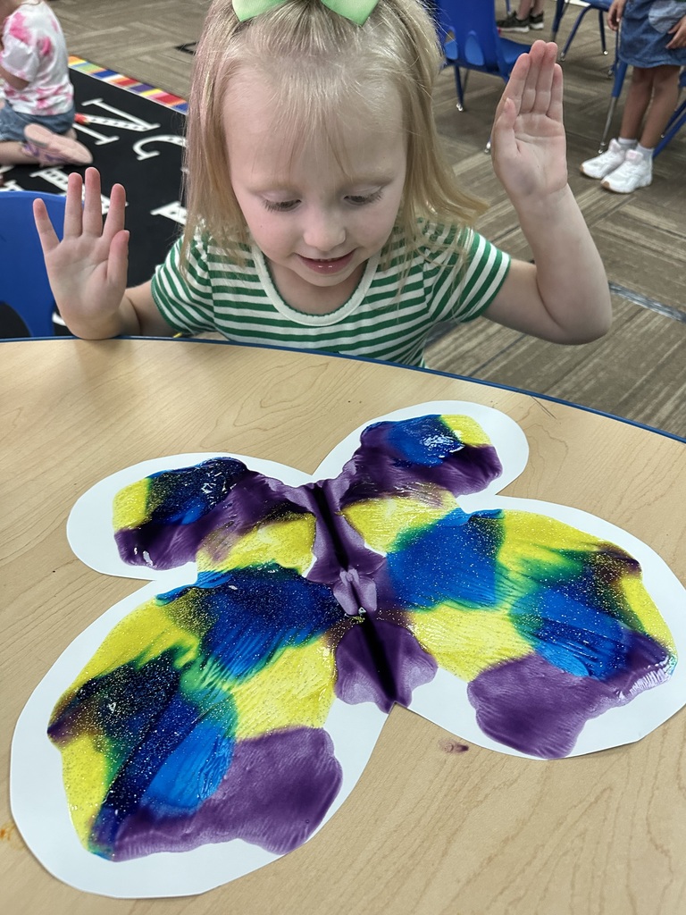 Little girl in green stripes & painting a butterfly