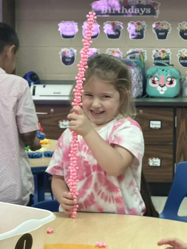 Little girl in pink playing with a pink toy