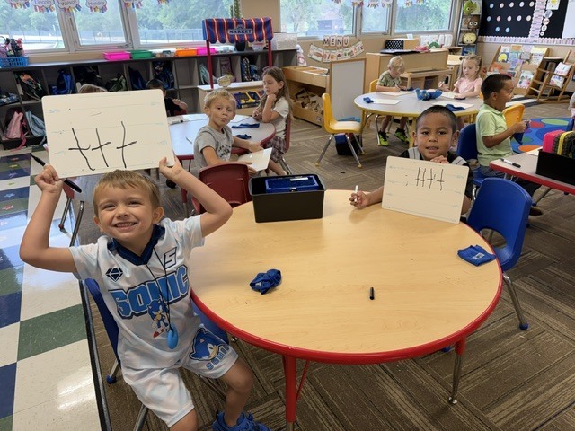 Boys showing their smart cookie drawings
