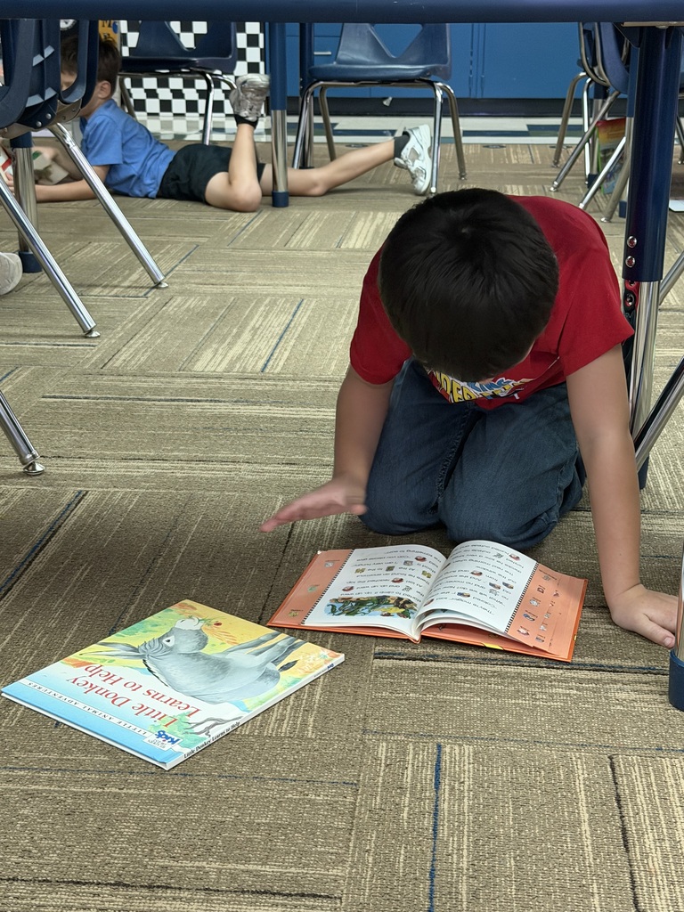 Young man crouched on the floor reading