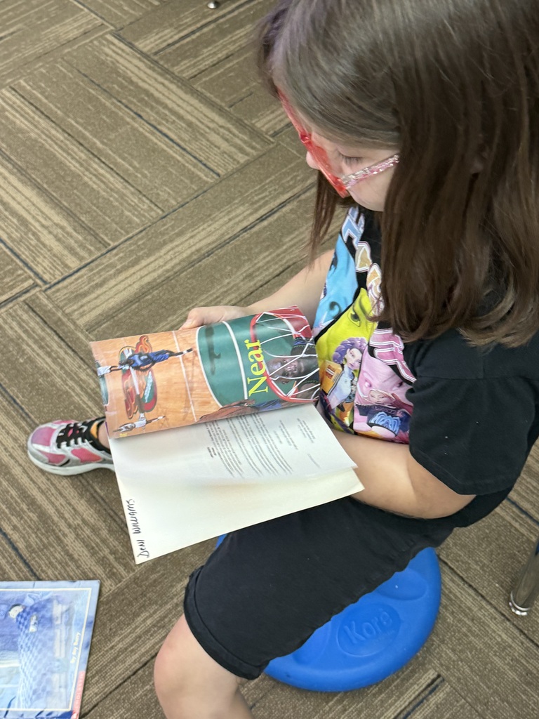Young girl sitting on a wobble stool reading