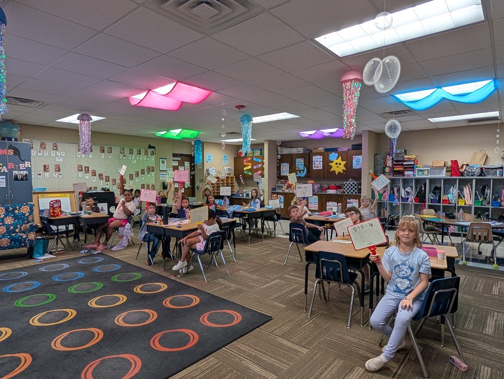 Ms. McCarter's class sitting with their whiteboards raised. They are practicing math facts to 20!